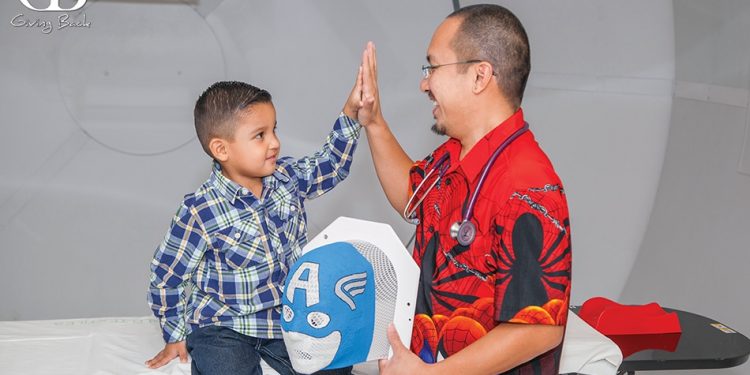 Andrew chang md a rady childrens radiation oncology specialist connects with a superhero loving patient