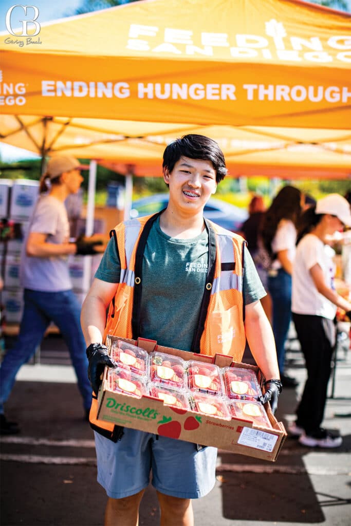 Volunteer lead Arthur Wang carries fresh rescued produce to be distributed at a Produce Pantry at Feed