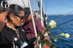 Roses are tossed into the sea as part of a memorial ceremony while sailing aboard the star of india