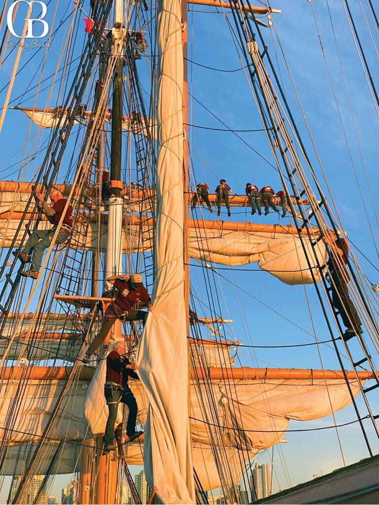 San Diego Maritime Museum volunteer crew members prepare to unfurl sails as the Star of India departs its berth along Harbor Drive