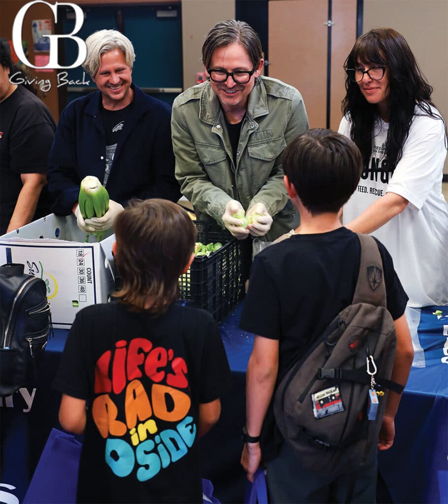 Switchfoot band members Tim Foreman and Chad Butler pass out food at a distribution at Libby Elementary The Switchfoot Bro Am Foundation has committed to funding a school pantry there through 2027
