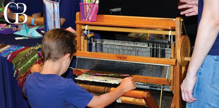 Boy learns to weave on a loom