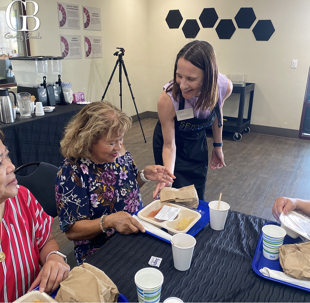 Melinda Forstey serves lunch to a Serving Seniors client at the Bay Terraces Community and Senior Center