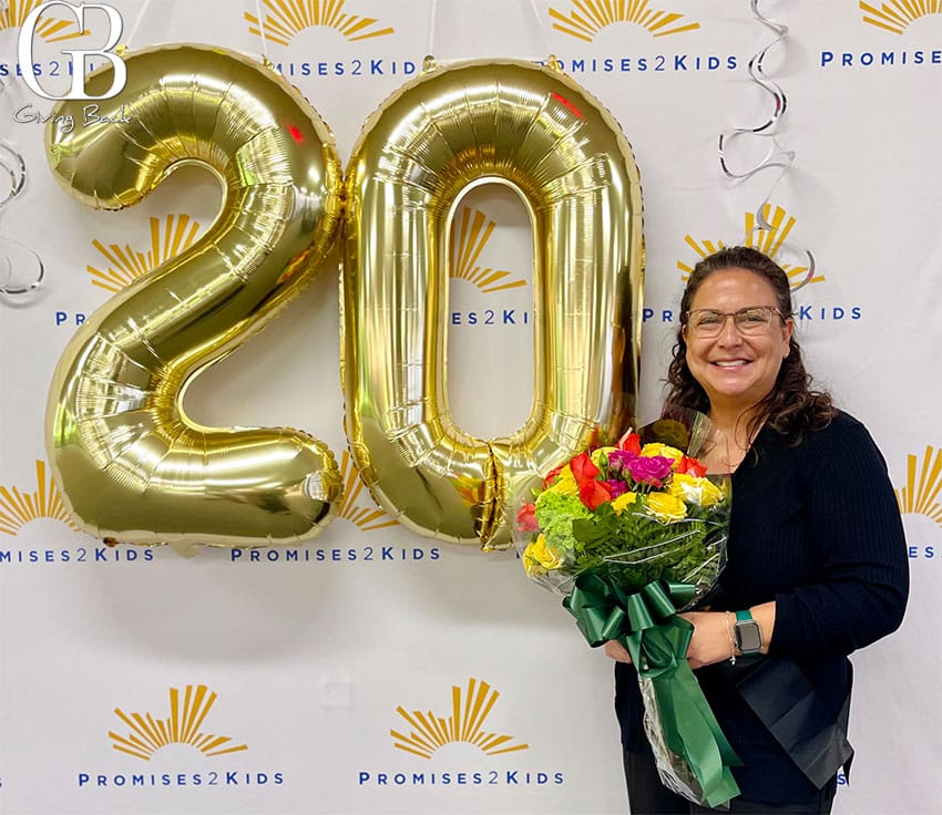 1'20' at a Promises 2 Kids celebration backdrop