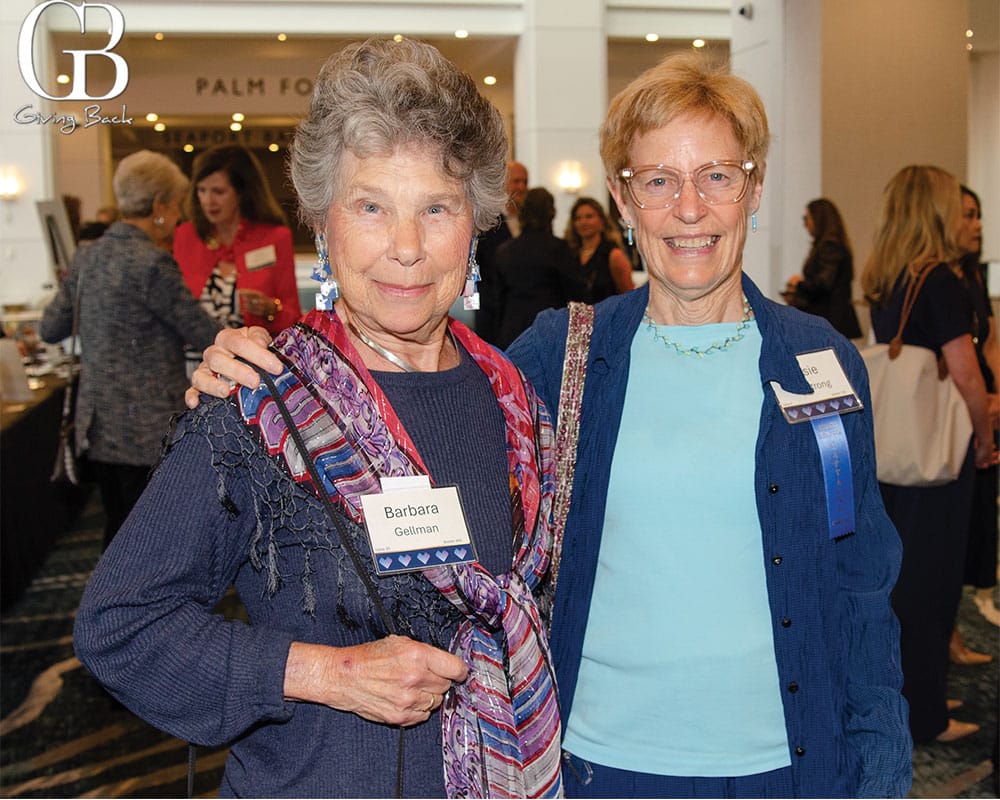 Barbara Gellman and Susie Armstrong'Barbara Gellman' and a colorful scarf. Behind them, other attendees mingle in a ballroom.
