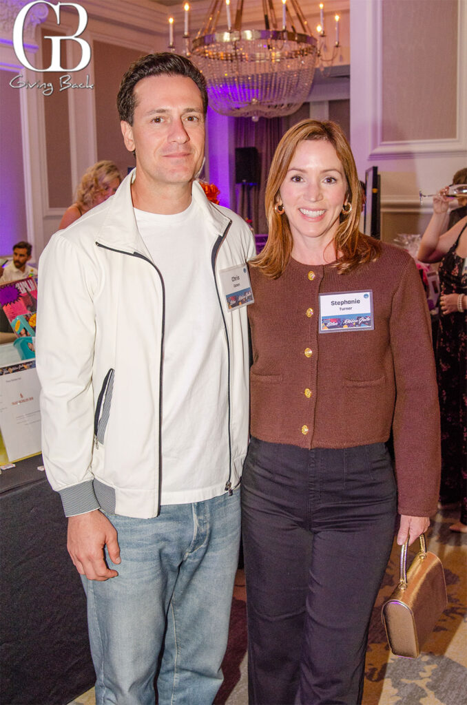 A worthy cause'Giving Back' logo in the top-left and a chandelier-lit ballroom in the background.