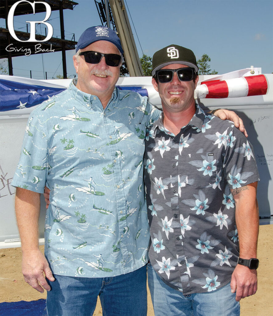 Chris Mueller and Jeremy Pribyl'Giving Back' logo visible in the background.