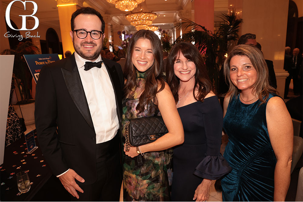 Daniel-and-Meghan-Domingo-with-Gayle-McMahon-and-Lori-Schleicher - GB Magazine Daniel and Meghan Domingo with Gayle McMahon and Lori Schleicher'Giving Back' logo in the corner.
