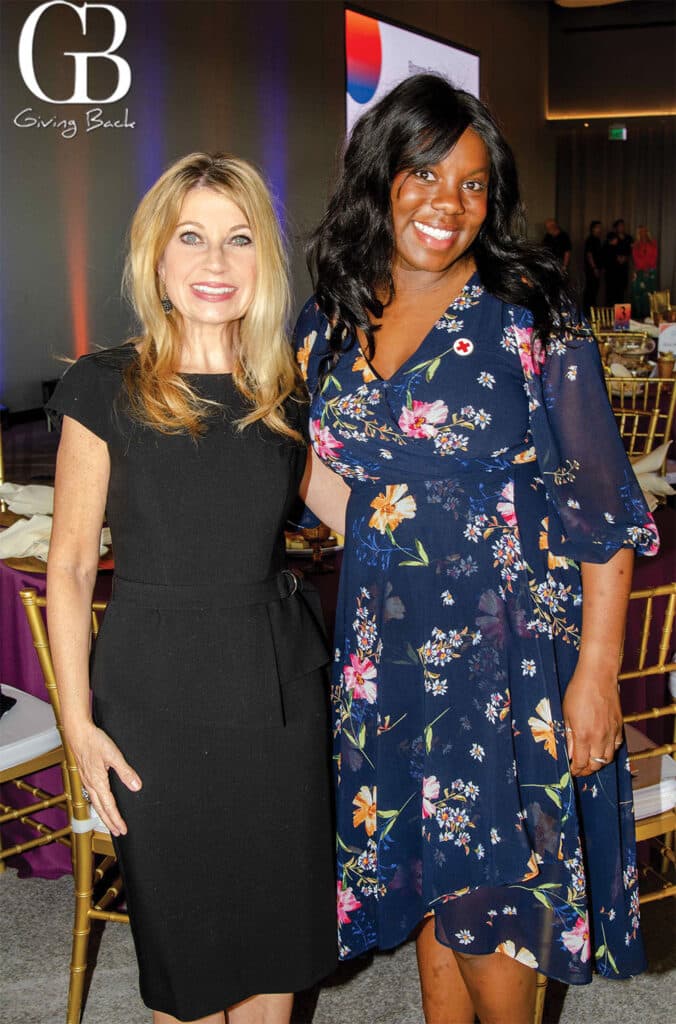Amy-Kennedy-and-Ashtyn-Nichols - GB Magazine Amy Kennedy and Ashtyn Nichols'Giving Back' logo in the background.