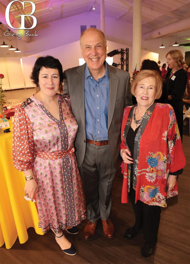 Carine-Harambillet-Sharp-Andrew-Sharp-and-Rose-Ann-Sharp - GB Magazine Carine Harambillet Sharp Andrew Sharp and Rose Ann Sharp'Giving Back' logo visible in the background.