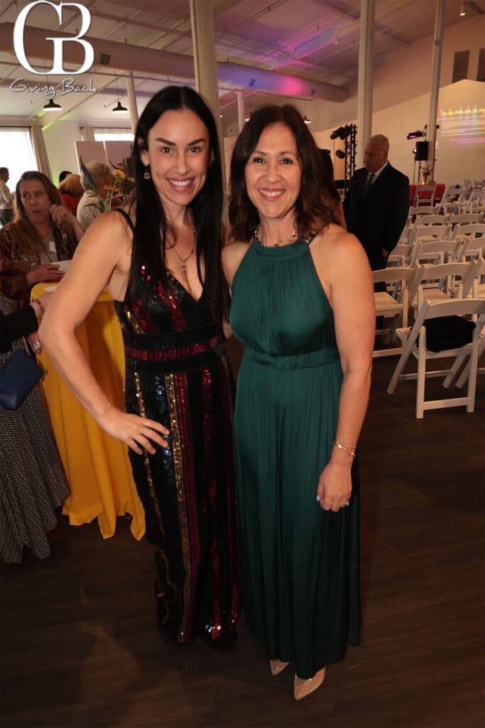 Corina-and-Shona-Borevitz - GB Magazine Corina and Shona Borevitz'Giving Back' logo in the background.