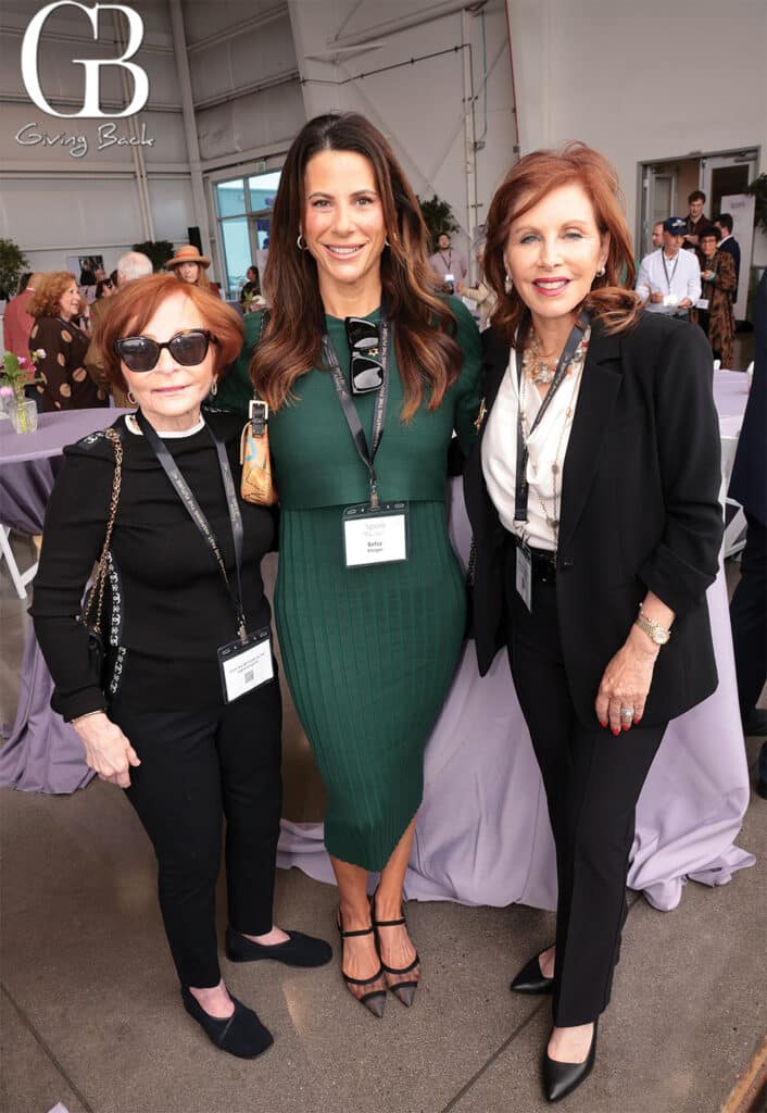 Ellen-Benkle-Betsy-Kleiger-and-Mary-Epsten - GB Magazine Ellen Benkle Betsy Kleiger and Mary Epsten'Giving Back' logo in the background on the left.